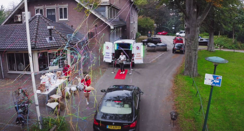 kerst dames met een auto en confetti en ee bus voor een woonhuis