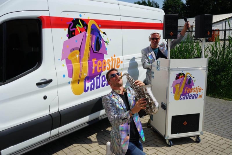 Een huis en tuin feestje rolt zo je huis in. saxofonist genield voor een mobiele dj booth die voor een bus staat samen met 2 mannen met een zonnenbril op